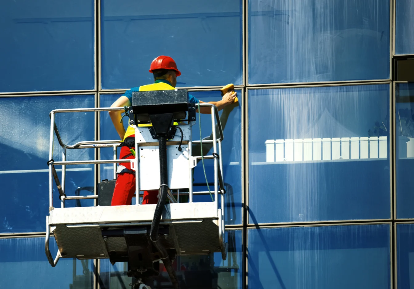 Worker cleaning high-rise building windows